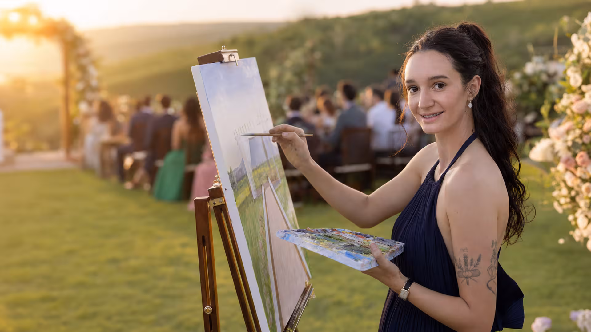 Kamilly Vitória realiza uma pintura ao vivo durante um casamento ao ar livre.